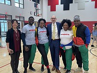 Superintendent Seth Harvatine poses for a photo with members of 29:11.