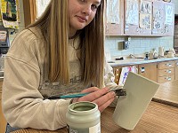 South student painting mug
