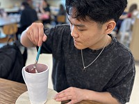South student glazing a mug