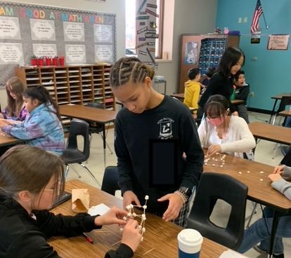 students building a tower from marshmallows and toothpicks
