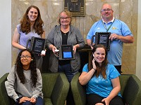 Kuck family with Urban Middle School library media specialist, principal and student displaying technology doanted by the Kuck family.