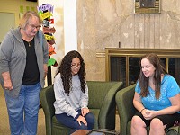 Translation technology using earbuds and an ipad are demonstrated to members of the Kuck family.