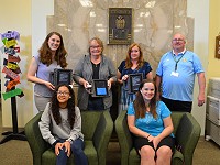 Kuck family with Urban Middle School library media specialist, teacher, principal and student displaying technology doanted by the Kuck family.